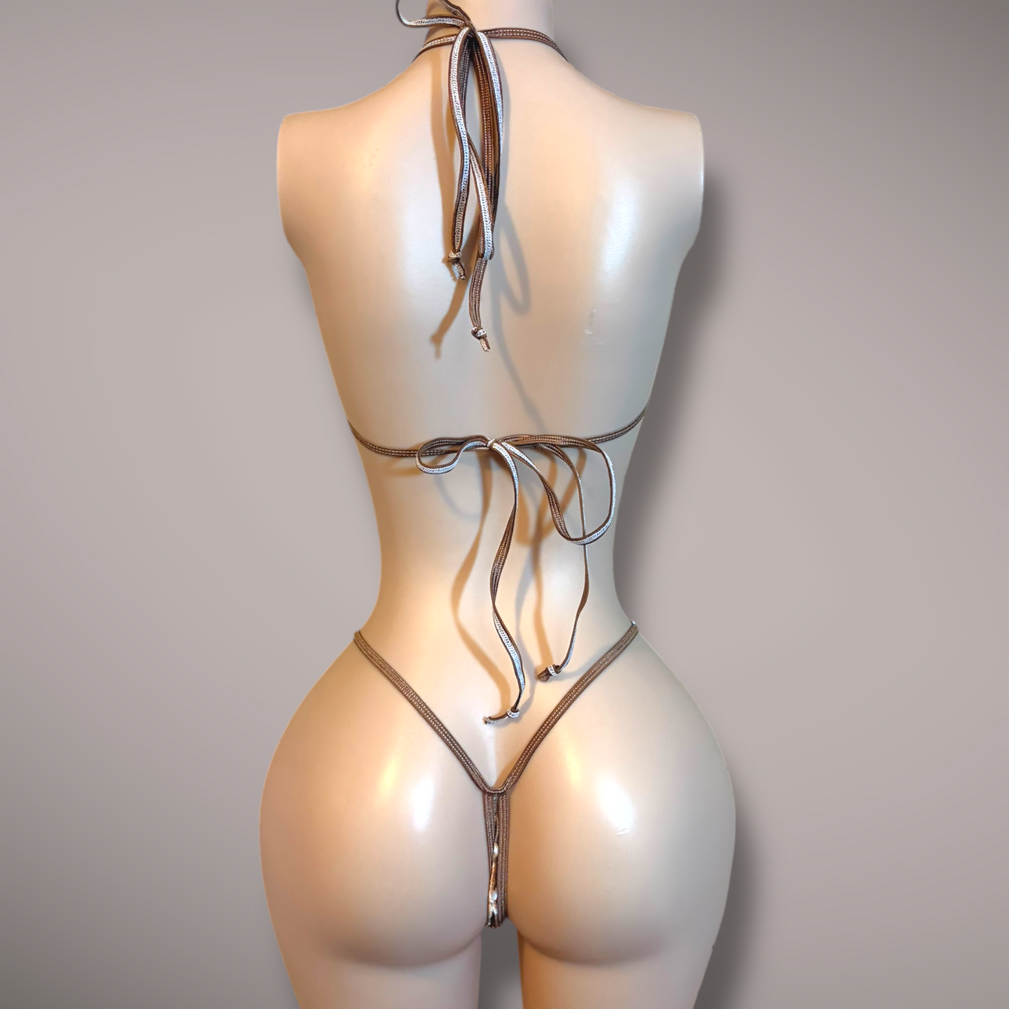 Mannequin wearing a velvet doe-print micro bikini set, featuring a minimal halter-style top and a matching thong bottom with thin straps, displayed against a neutral background