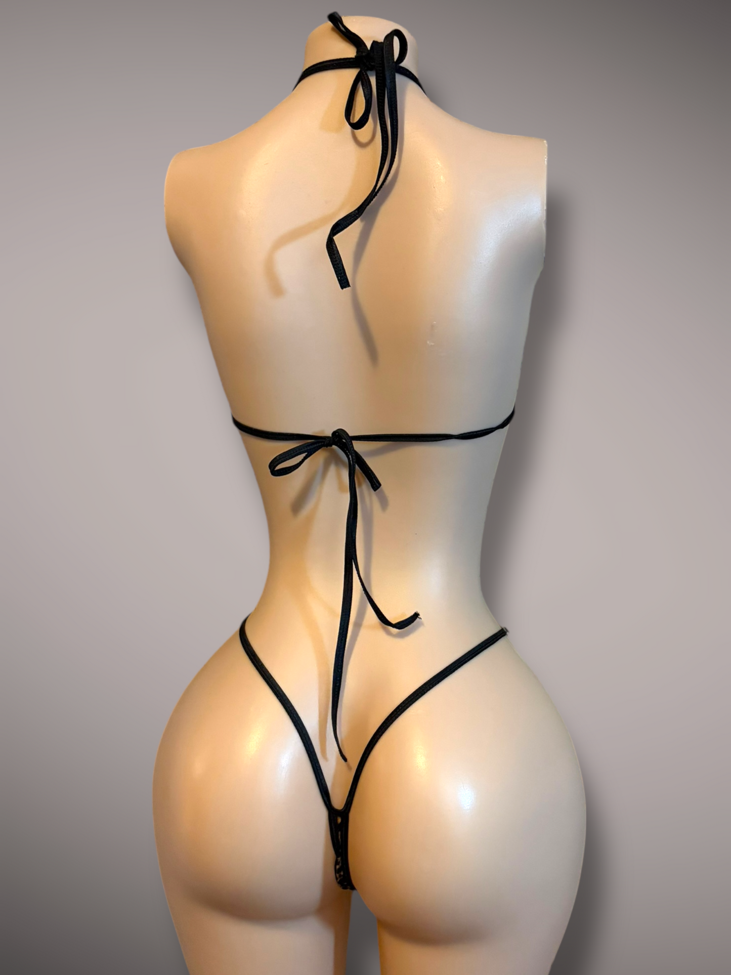 Back view of a velvet cheetah print bikini displayed on a mannequin, showcasing the tie closures and minimal coverage.