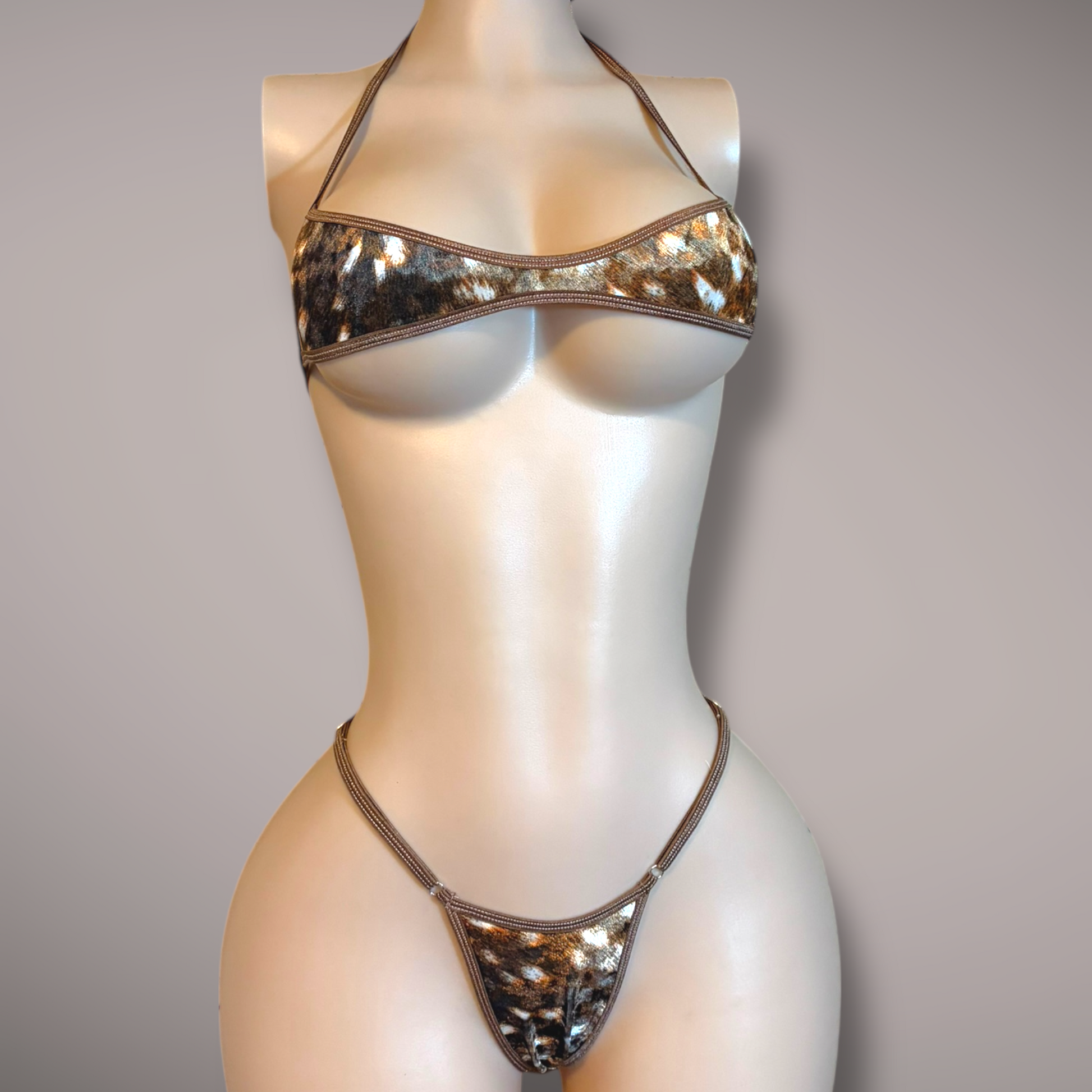 Mannequin wearing a velvet doe-print micro bikini set, featuring a minimal halter-style top and a matching thong bottom with thin straps, displayed against a neutral background