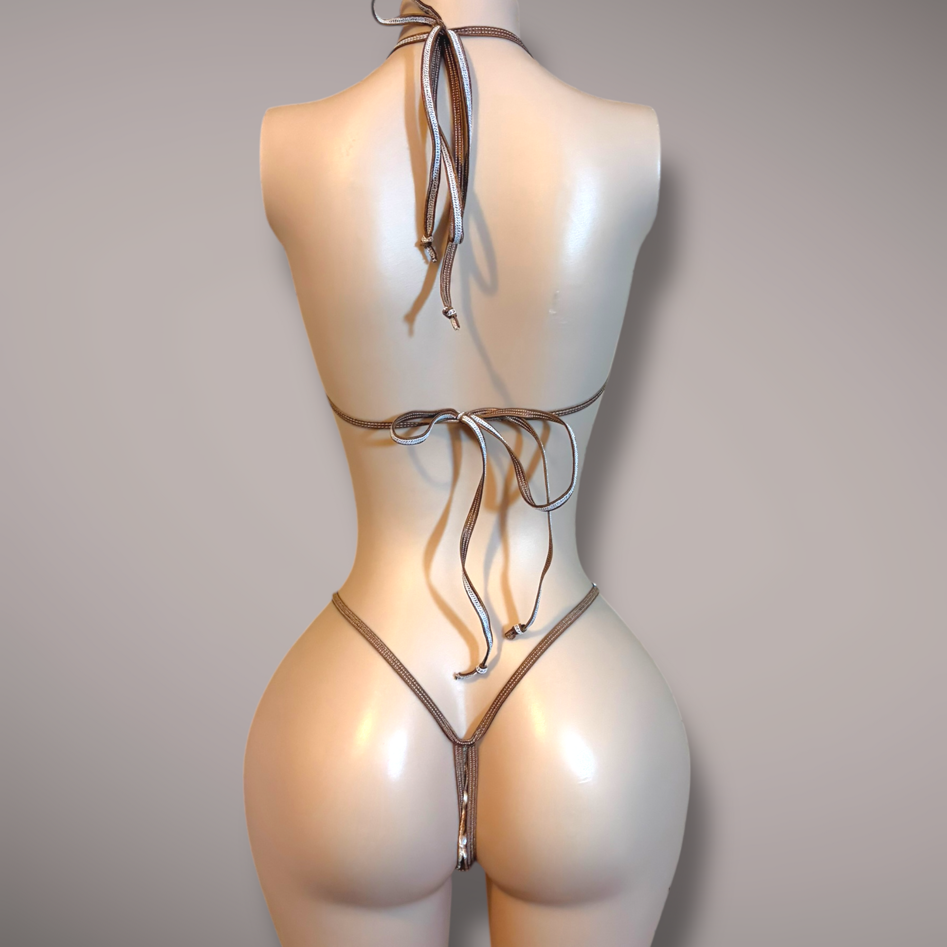 Mannequin wearing a velvet doe-print micro bikini set, featuring a minimal halter-style top and a matching thong bottom with thin straps, displayed against a neutral background